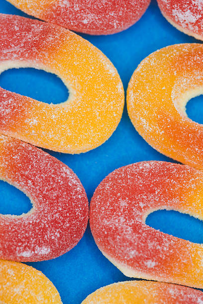 Vibrant Gummy Candy Rings Flat Lay - Orange Peach Rings on Blue Background