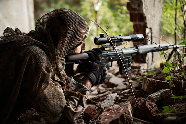 Soldier aiming his weapon in forest area.