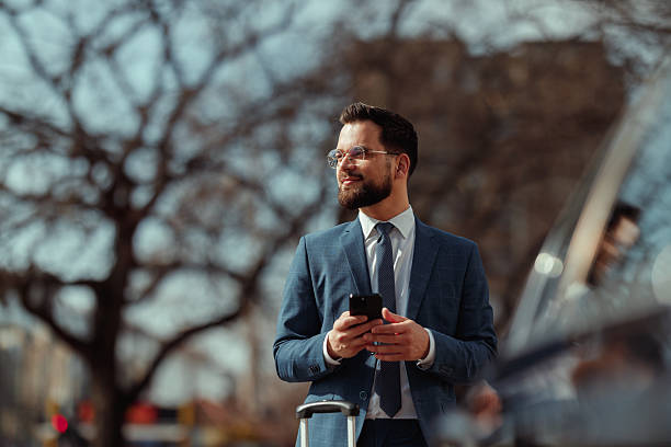 istock Businessman With Suitcase Checking Phone 2210668180