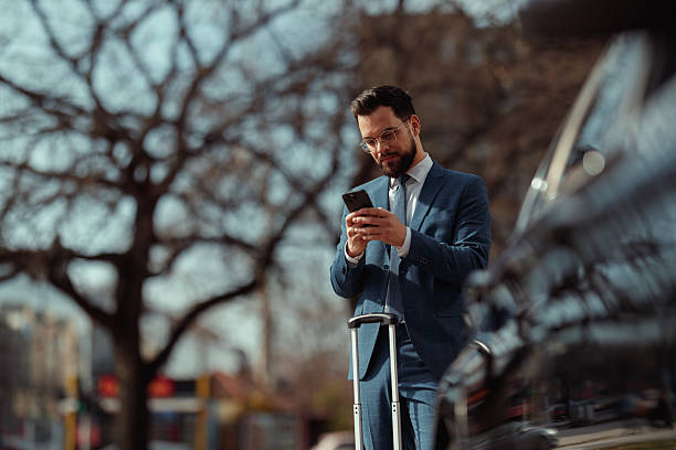 istock Businessman With Suitcase Checking Phone 2210668185