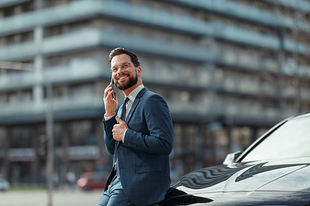 istock Businessman Talking on Phone by Car 2210668218