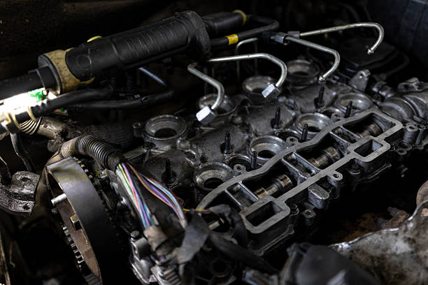 istock A close-up shows the upper part of a partially disassembled engine inside a vehicle, illuminated by a work light. 2210668454