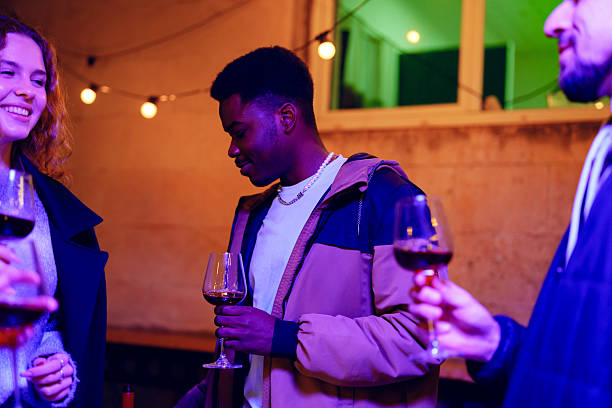 istock Friends enjoying a lively evening with wine in a cozy venue decorated with string lights 2210671098