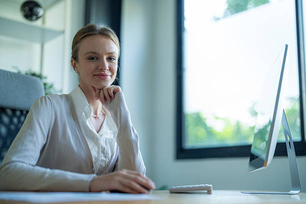 istock Professional woman working at a desk in a modern office environment during daylight 2210674197
