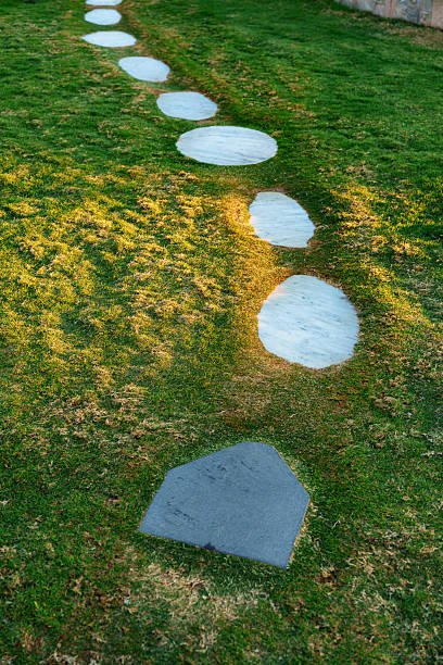 istock Curved stone pathway in a green garden during sunset showcasing natural landscaping 2210675229