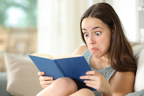 istock Perplexed woman reading a paper book in a house 2210679017