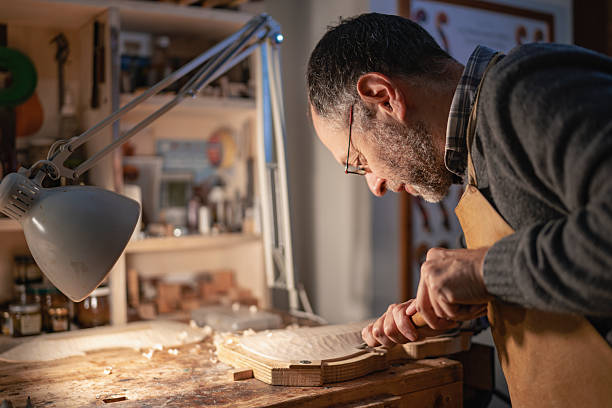 istock Italian violin maker concentrating on crafting a violin in his workshop 2210679121
