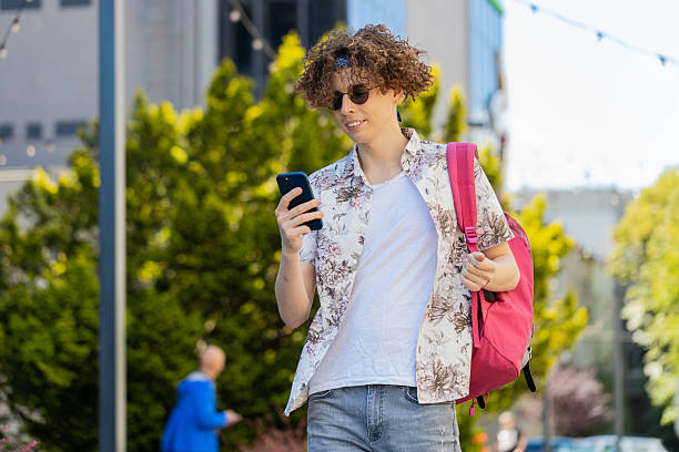 istock Tourist man using smartphone typing texting social media messages e-mail looking for a way on map 2210680839