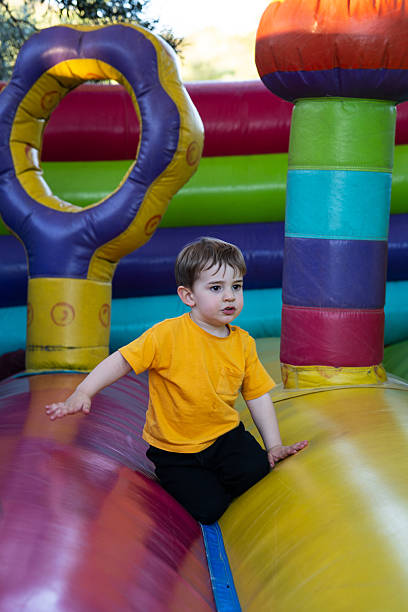 istock Child kneeling on inflatable bouncy castle, playing and having fun 2210680852