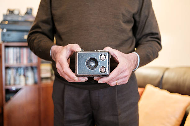 Senior man holding a very old bakelite camera in his hands