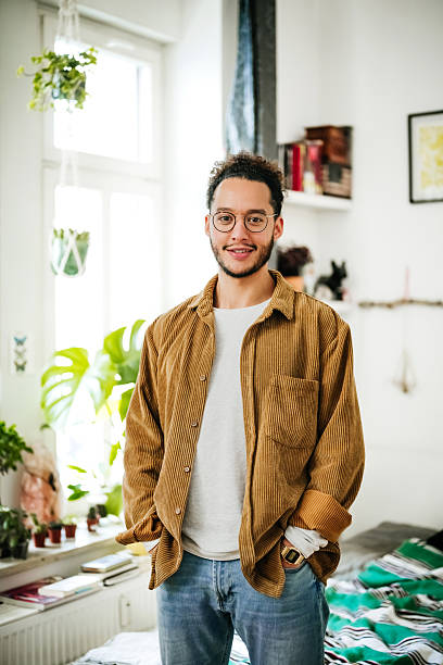 istock Young man standing confidently in bright student apartment bedroom 2210683567