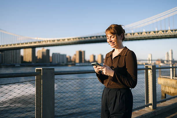 istock Happy businesswoman using cell phone on the move by the river. 2210683865