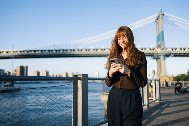 istock Happy woman using smart phone during a walk by the river. 2210684054