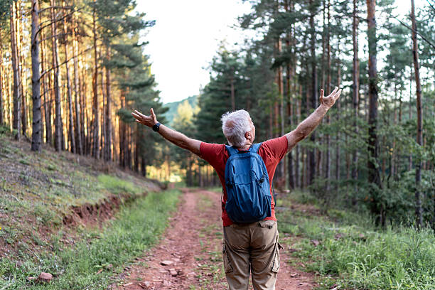 istock Senior hiker enjoying freedom in nature with open arms 2210685555