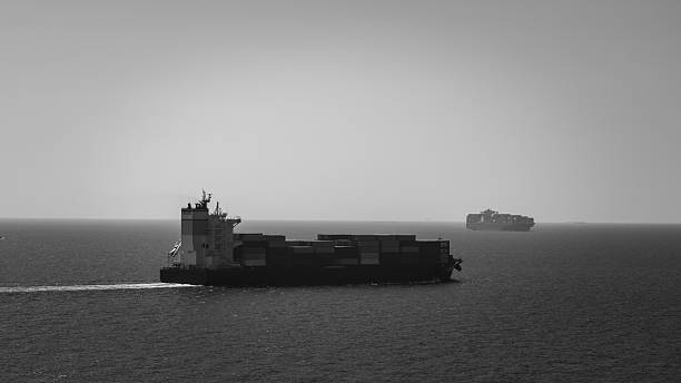 istock container ship carrying goods for international import export, business and industry regarding cargo transportation services to consumers and dealers by container ship around the world, black and white. 2210688621