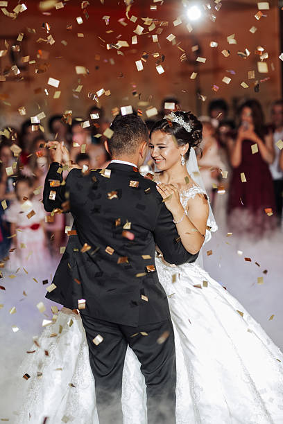 istock A bride and groom are dancing in the air with confetti falling around them 2210690165