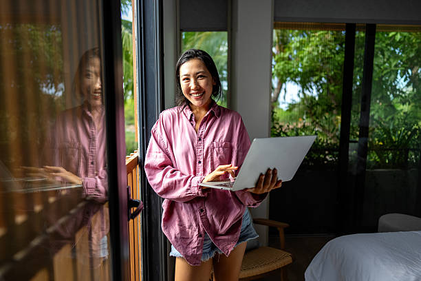 istock Middle eastern, asian woman working on a laptop in a tropical-inspired home office 2210690784