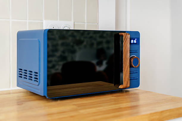 istock Modern kitchen with blue microwave and wooden accents for stylish cooking 2210692284