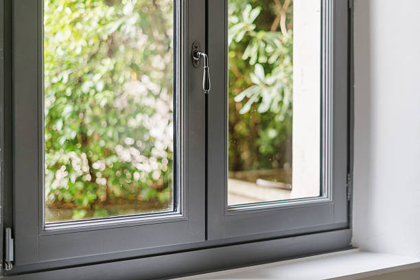 istock Modern window frame in a living room overlooking a lush green garden 2210692348