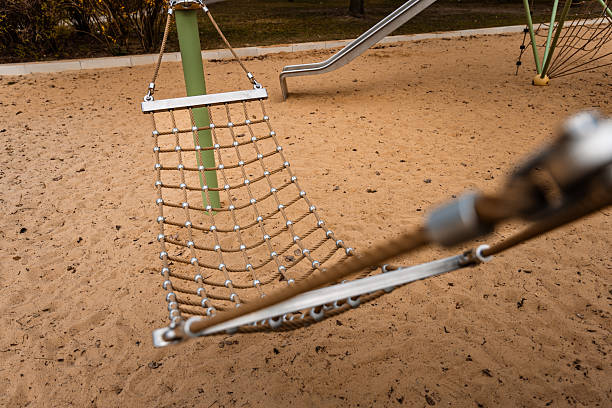 Close-up of a securely fastened steel rope used in a children's playground climbing net. The image focuses on safety hardware and textured material, emphasizing construction quality in modern public play areas.