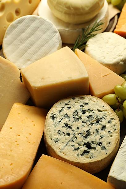 istock Different types of cheese, rosemary and grapes on table, closeup 2210692782