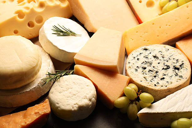 istock Different types of cheese, rosemary and grapes on table, closeup 2210692788
