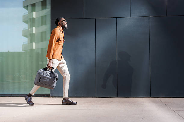 Man walking outdoors carrying a bag in an urban environment