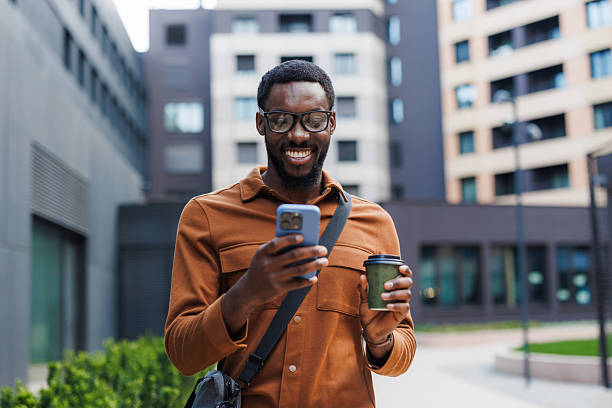 istock Young man enjoying coffee and checking his smart phone on his way to work 2210693593