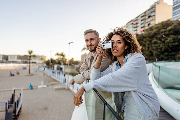 istock Two Friends Enjoying A Scenic View While Taking Photos Near The Beach 2210694061