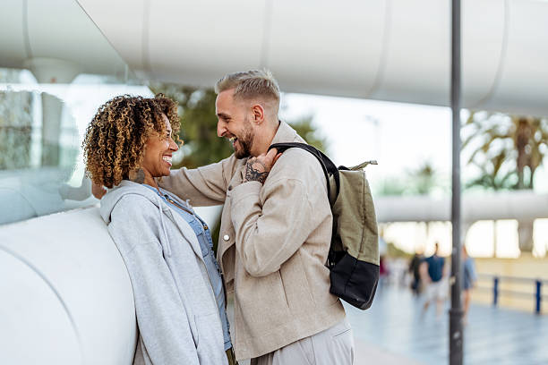 istock Happy Couple Smiling Outdoors During a Casual Chat in a Modern Setting 2210694510