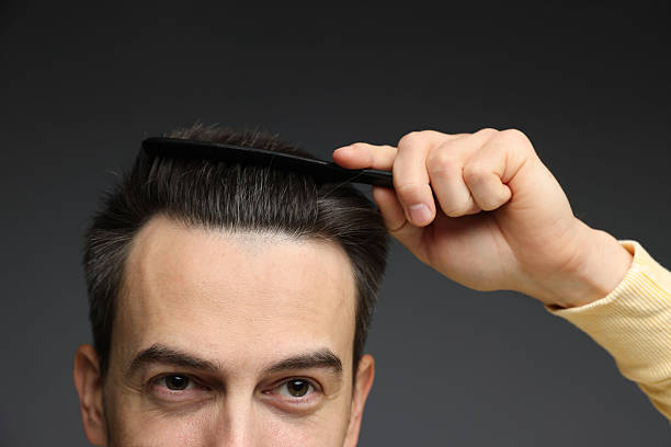 istock Handsome man combing his hair on dark background, closeup 2210695892