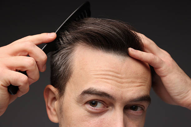 istock Handsome man combing his hair on dark background, closeup 2210695918