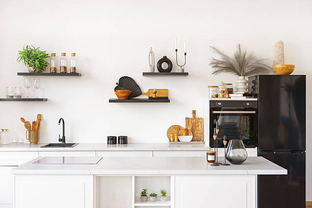istock Kitchen interior with countertop and black water tap on white wall background with wooden shelves 2210695927