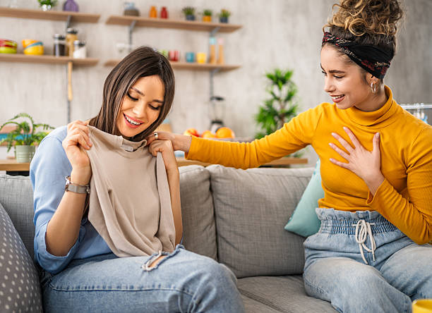 istock Two young women having fun trying on clothes at home 2210698637