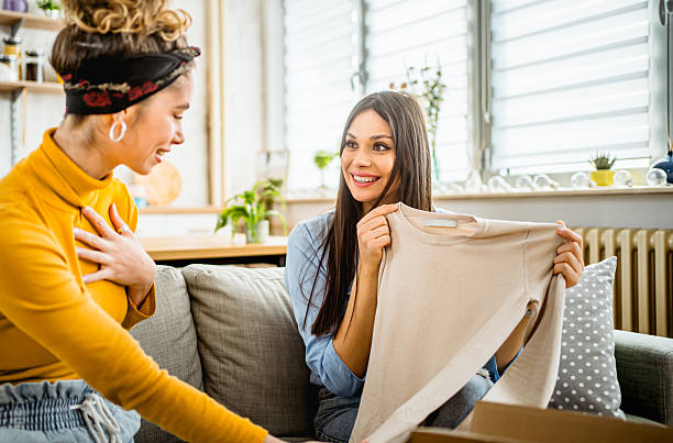 istock Two young women unpacking clothes from a delivery box at home 2210698726