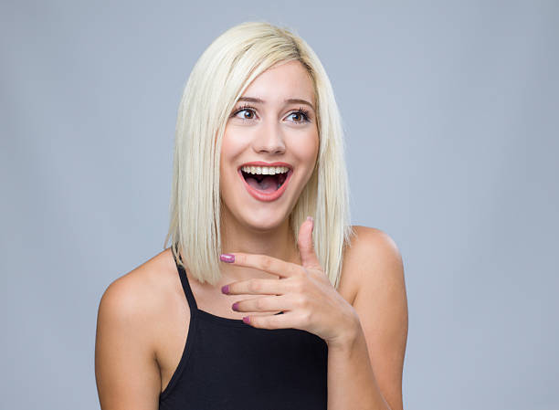 Surprised young woman portrait, gray background,