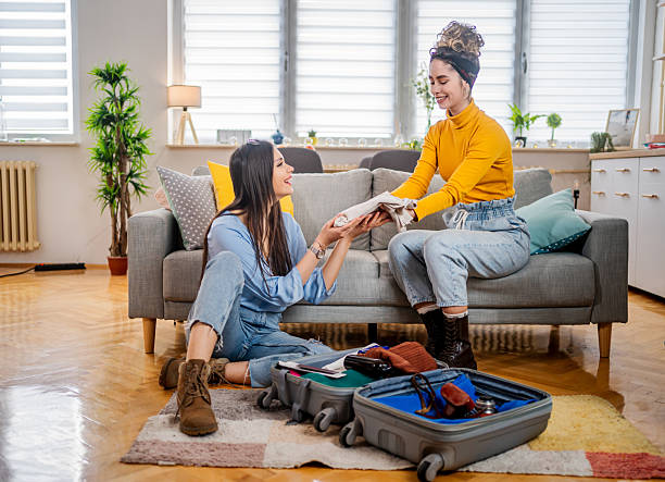 istock Two young women organizing clothes in suitcase for a trip 2210699486