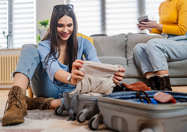 istock Two young women organizing clothes in suitcase before trip 2210699637