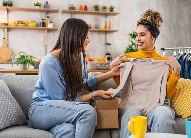 istock Two young women unpacking clothes from a delivery box at home 2210699729