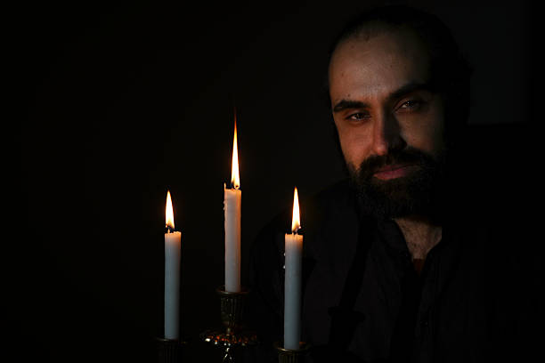istock Candlelit Contemplation by a Bearded Man in Darkness 2210700001