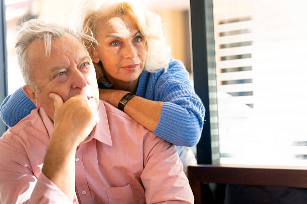 istock Worried senior couple embracing at restaurant table 2210700284