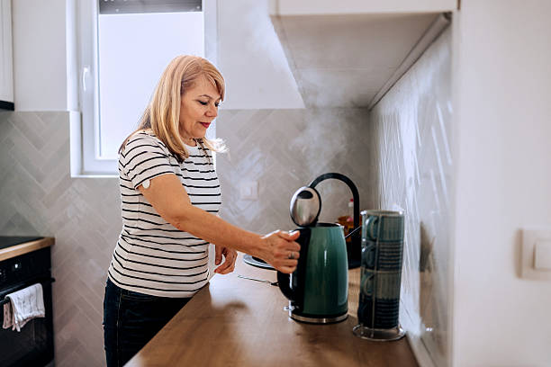 istock Senior woman making coffee in kitchen 2210704855