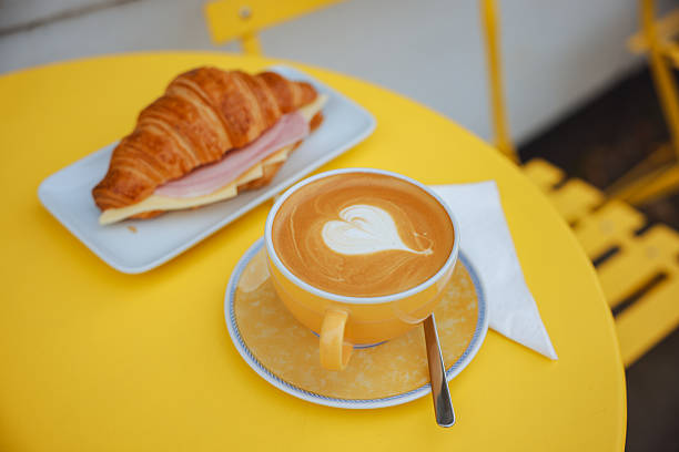 Croissant with ham and cheese. Cup of coffee. Closeup. Ham cheese scrambled eggs croissant for breakfast. toning