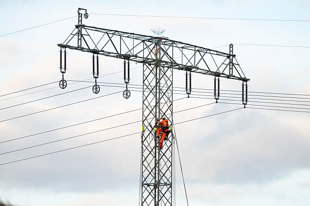 electric worker team changing high voltage transmission lines on pole