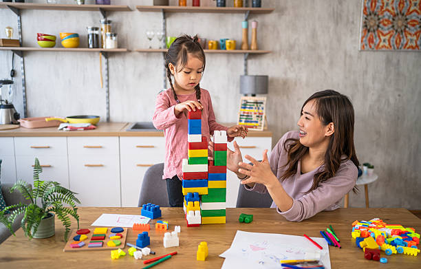 istock Mother and daughter building with blocks at home 2210707201
