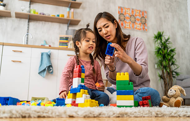 istock Mother and daughter building with blocks at home 2210707639
