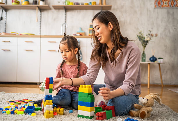 istock Mother and daughter building with blocks at home 2210708178