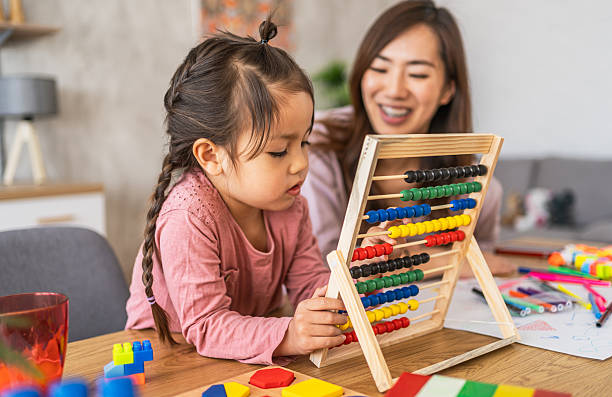 istock Little girl learning numbers with an abacus and her mother 2210708565