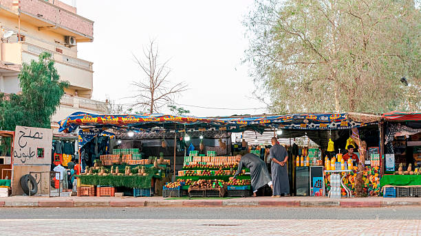 Tamanrasset, Algeria- March 22, 2025: a vendor sells natural fruit juice, with coconuts, pineapples, mangoes, and juice cans. A cardboard in Arabic reads: \