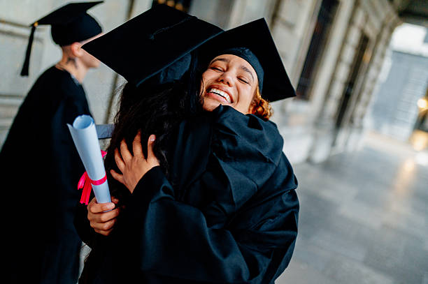 istock Happy graduates hugging after graduation ceremony 2210711810
